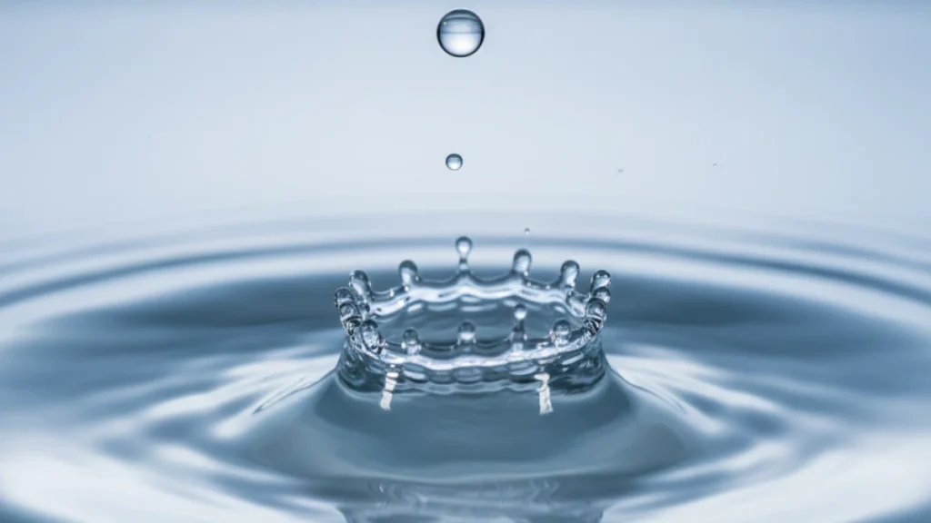 High-speed macro photography of a water drop creating a perfect ripple in soft blue tones, symbolizing the continuous renewal cycle of the intestinal epithelium.